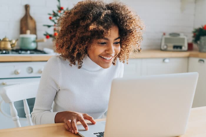 Woman happily using a laptop