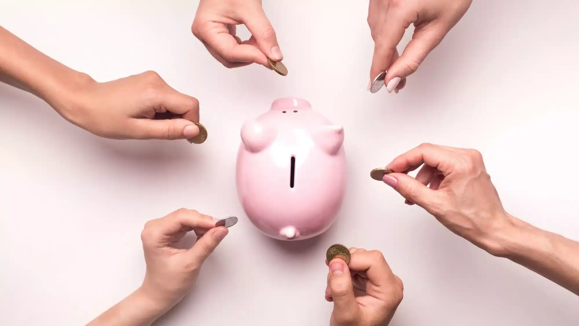 Crowd funding concept showing multiple hands contributing coins to a piggy bank for a product launch