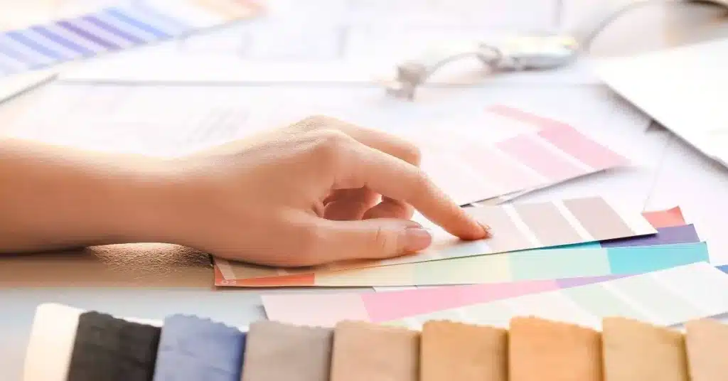 Hand choosing color swatches during product branding design and visual identity development.